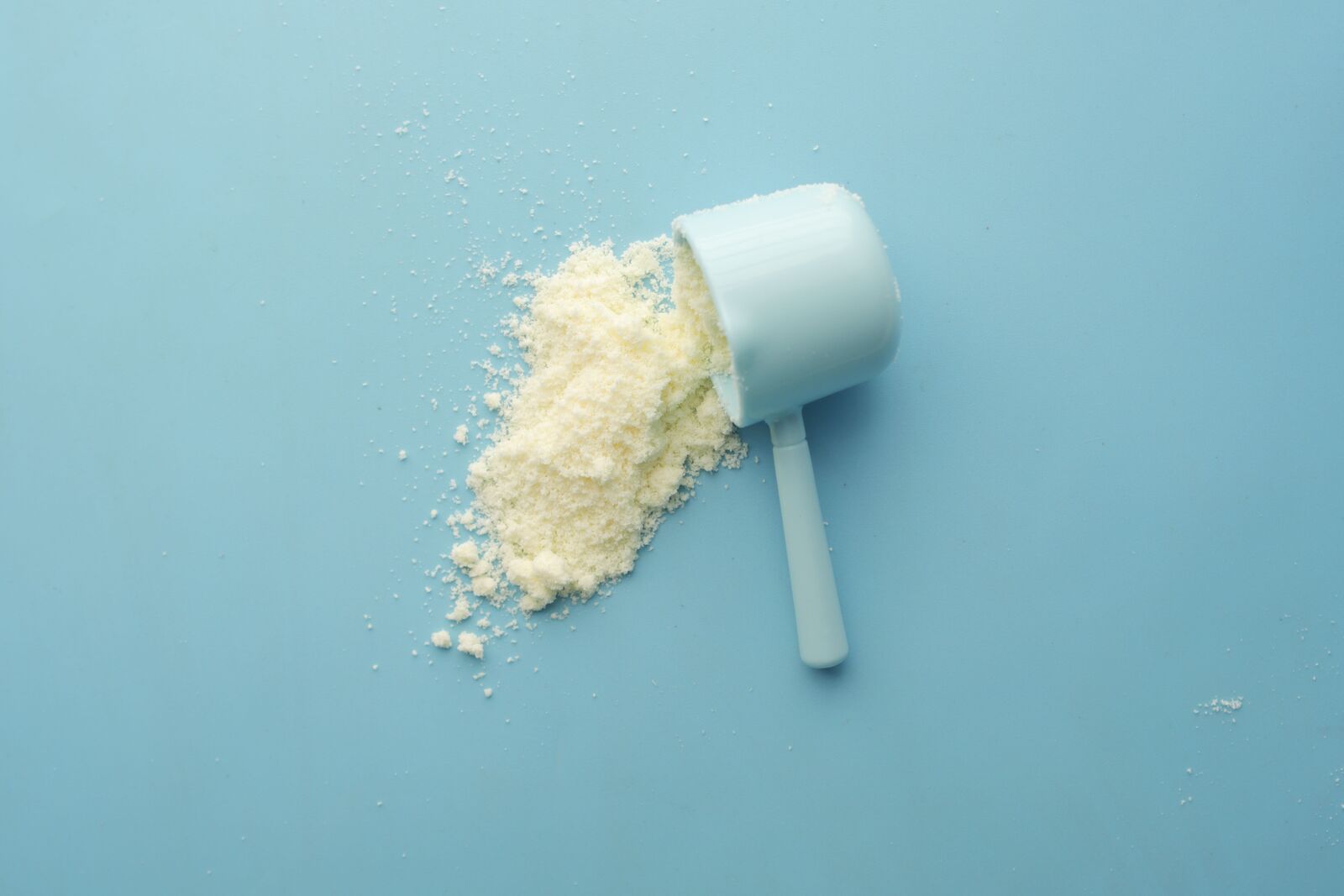 Whey protein powder spilling from a scoop