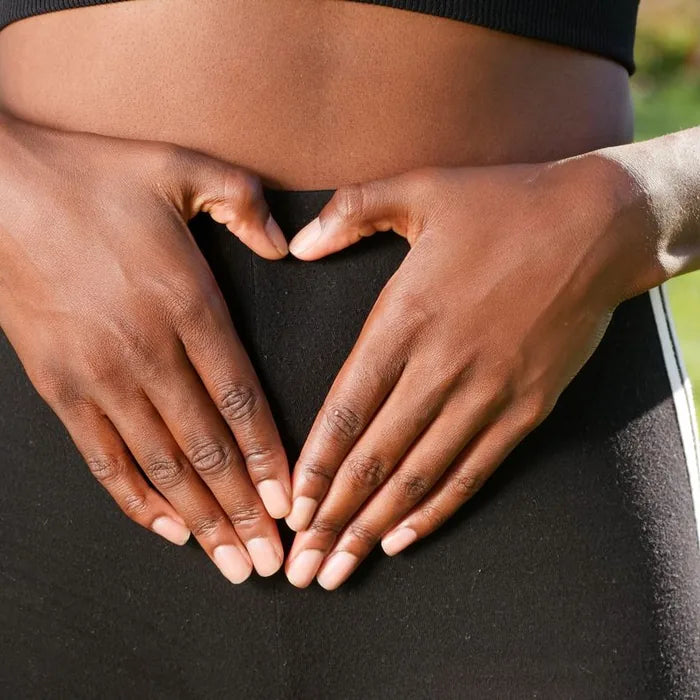 Hands forming a heart over the stomach for gut health