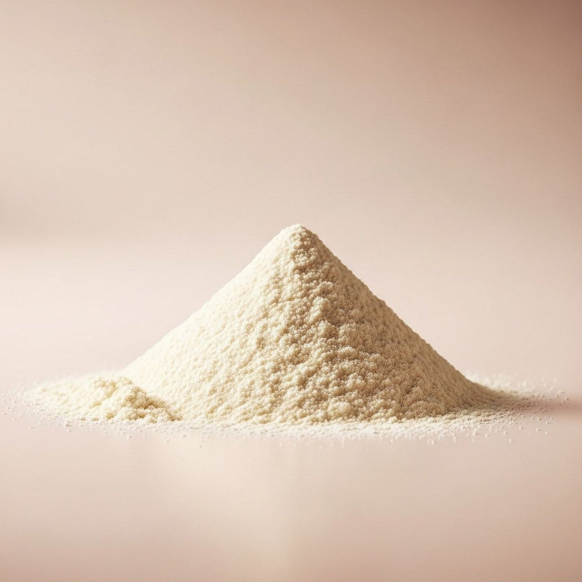 A small mound of Protelicious True Original whey protein powder on a soft beige surface