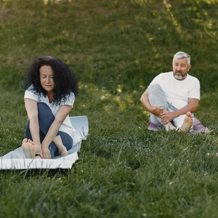 Couple stretching and doing yoga outdoors