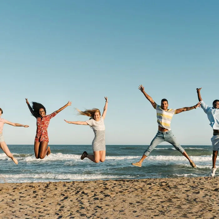 Friends jumping joyfully on the beach